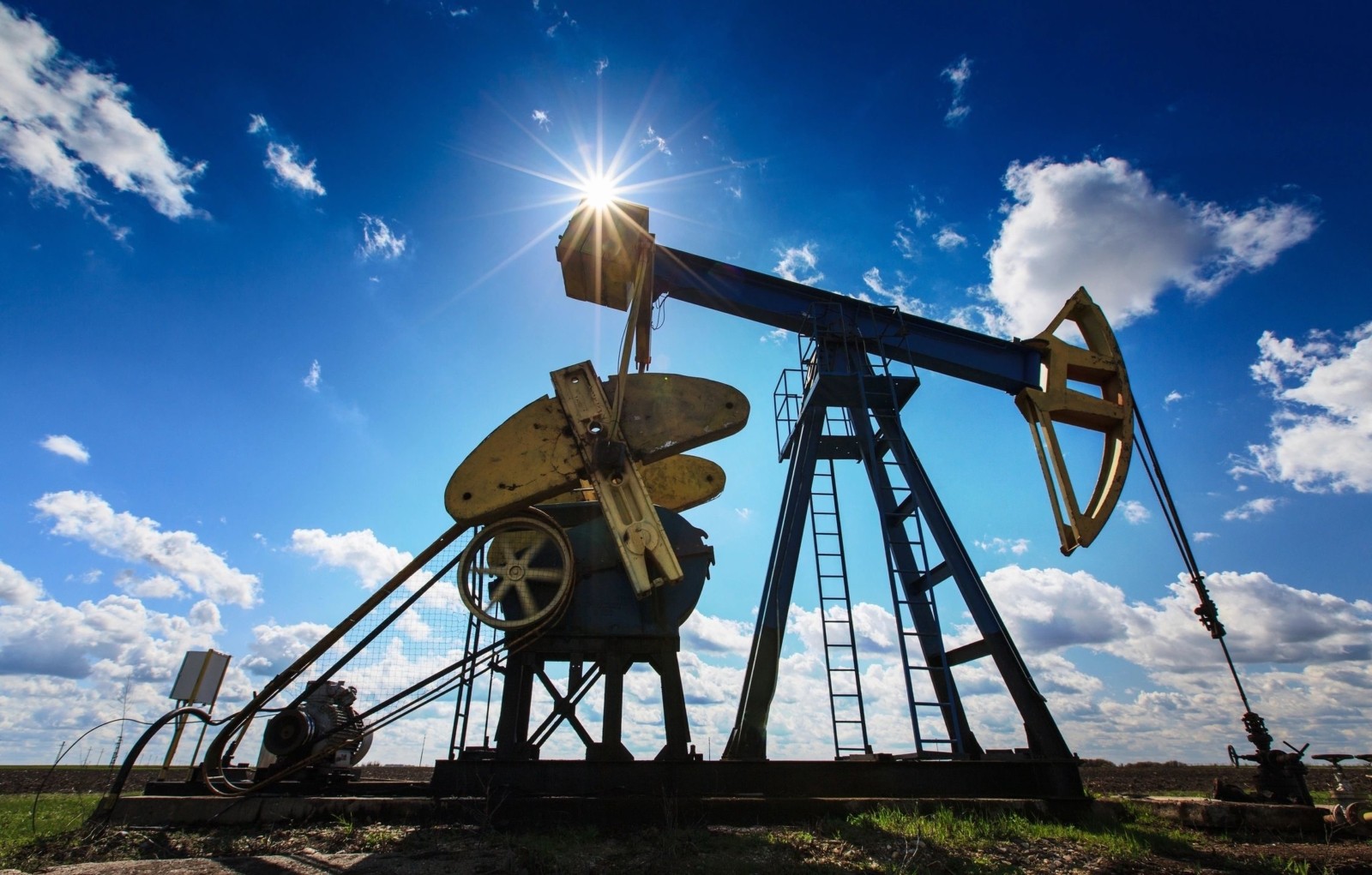 This iamge shows an Oil Rig in a sunny field.